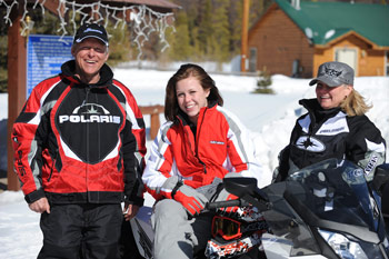 A famiy snowmobiling together