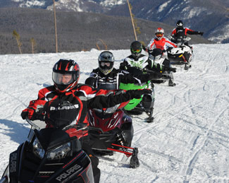 Snowmobilers following basic hand signals