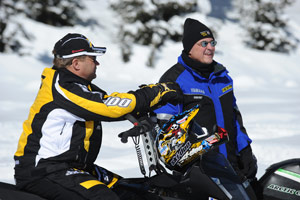 Men riding their sleds along a groomed path